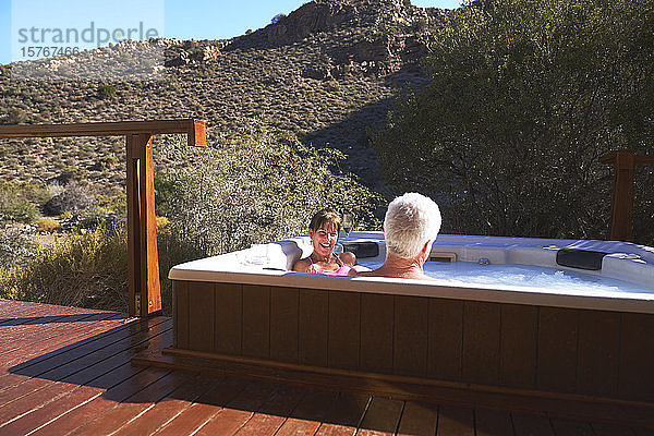 Glückliches älteres Paar entspannt sich im Whirlpool auf dem sonnigen Safari-Balkon