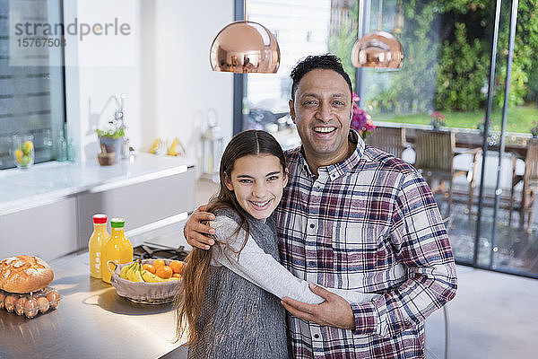 Porträt glücklicher Vater und Tochter  die sich in der Küche umarmen