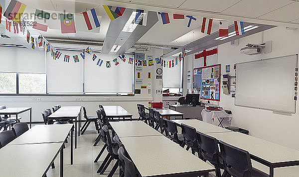 Nationalflaggen hängen über den Tischen im Klassenzimmer