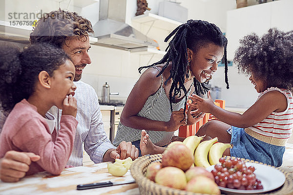 Junge Familie isst Obst auf dem Tisch