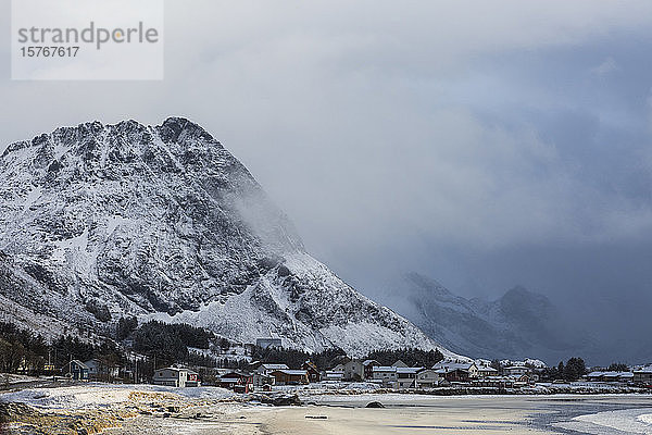 Schneebedeckter Berg über dem abgelegenen Dorf Ramberg auf den Lofoten Norwegen