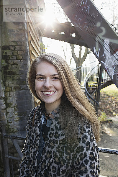 Porträt lächelnde junge Frau im Stadtpark
