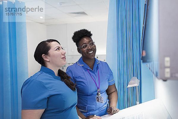 Ärztin und Krankenschwester untersuchen Röntgenbilder in einem Krankenhauszimmer