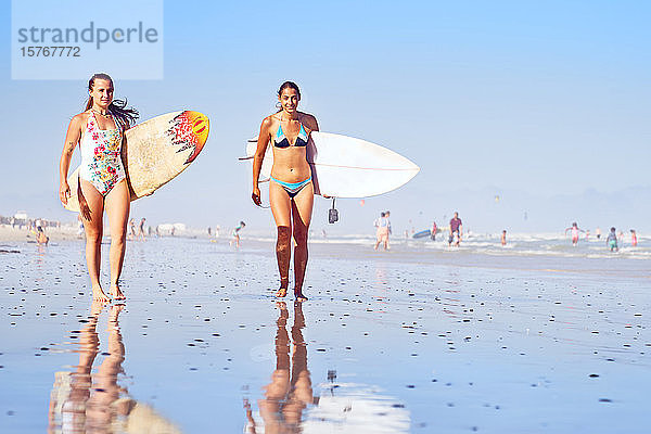 Porträt zuversichtlich  junge Surferinnen auf sonnigen Ozean Strand