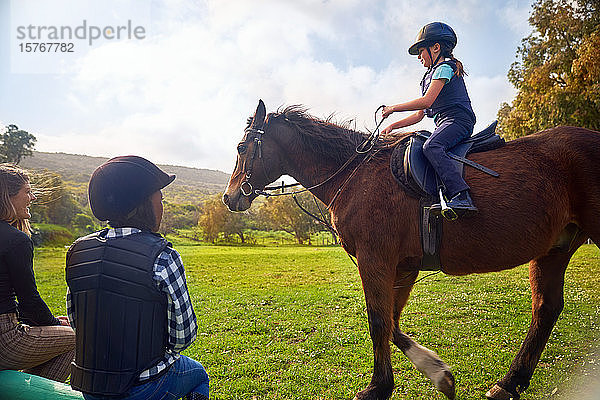 Mädchen lernt Reiten auf einer ländlichen Pferdekoppel