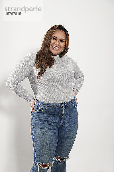 Porträt selbstbewusste junge Frau in Pullover und Jeans