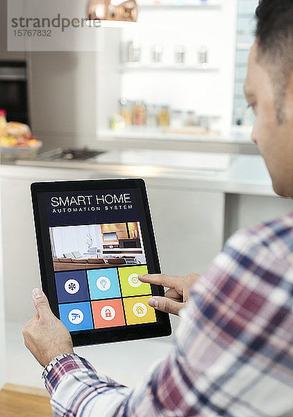 Mann steuert Smart-Home-Navigationssystem über digitales Tablet in der Küche