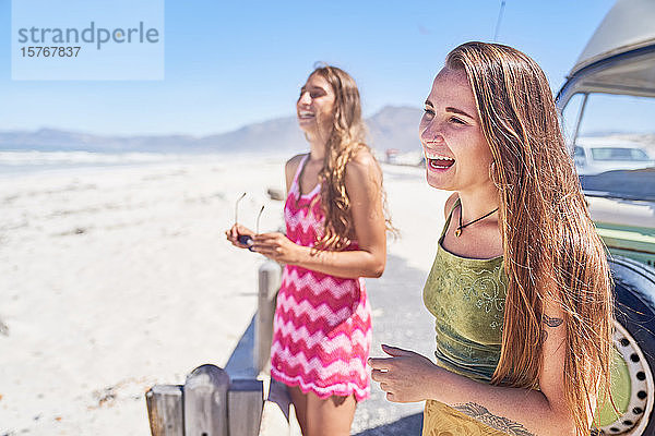 Glückliche junge Frauen Freunde lachen am sonnigen Strand