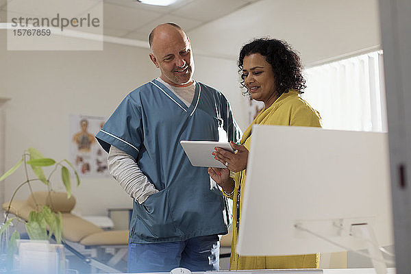 Ärzte in der Sprechstunde  mit digitalem Tablet in der Arztpraxis