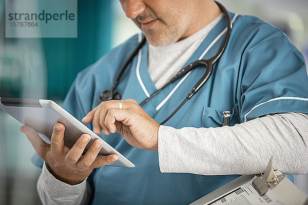 Männlicher Arzt mit digitalem Tablet