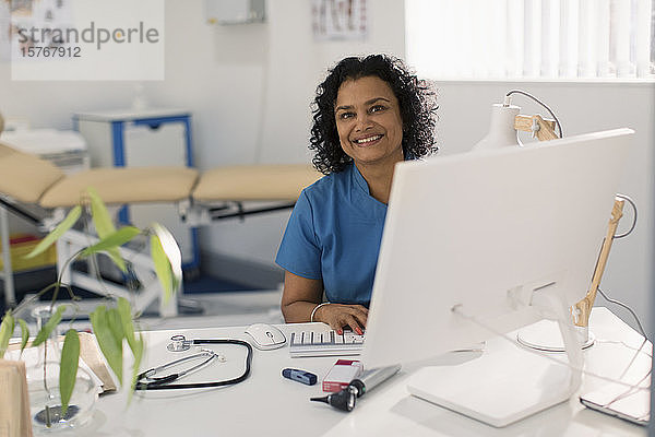 Porträt einer selbstbewussten Ärztin bei der Arbeit am Computer in einer Arztpraxis