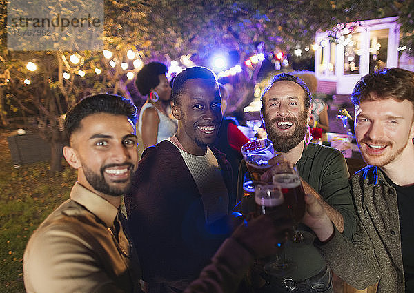 Porträt glücklicher männlicher Freunde beim Trinken auf einer Gartenparty