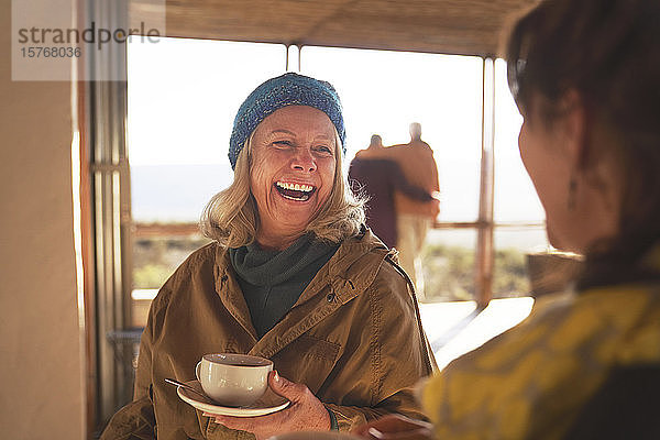 Glückliche Seniorinnen  die Kaffee trinken und lachen