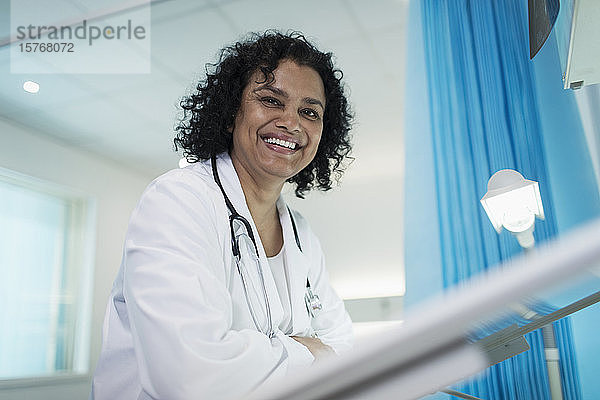 Porträt einer selbstbewussten  lächelnden Ärztin in einem Krankenhauszimmer