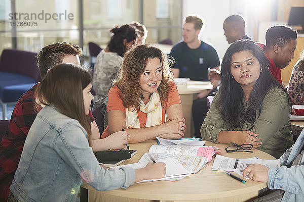 College-Studenten lernen und unterhalten sich am Bibliothekstisch