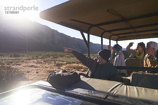 Safari-Guide und Gruppe im sonnigen Geländewagen