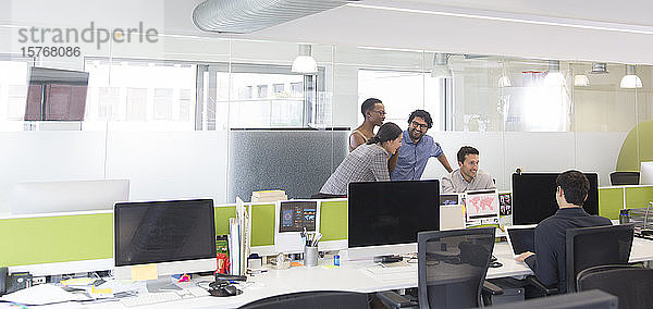 Geschäftsleute im Gespräch  Treffen am Computer in einem Großraumbüro