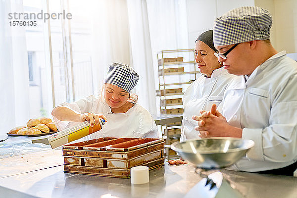 Koch und Schüler mit Down-Syndrom backen Brot in der Küche