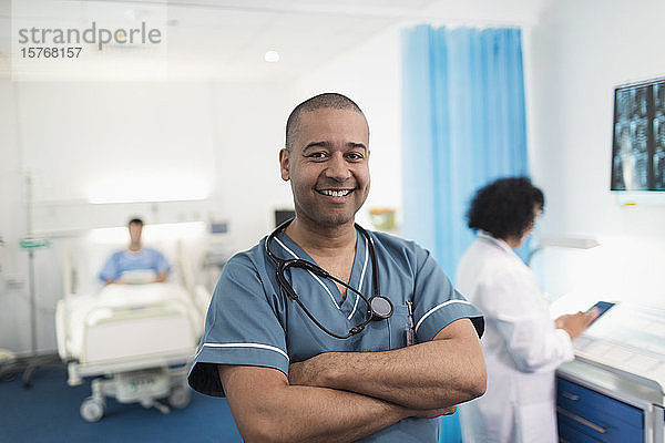 Porträt eines selbstbewussten  lächelnden Krankenpflegers in einem Krankenhauszimmer
