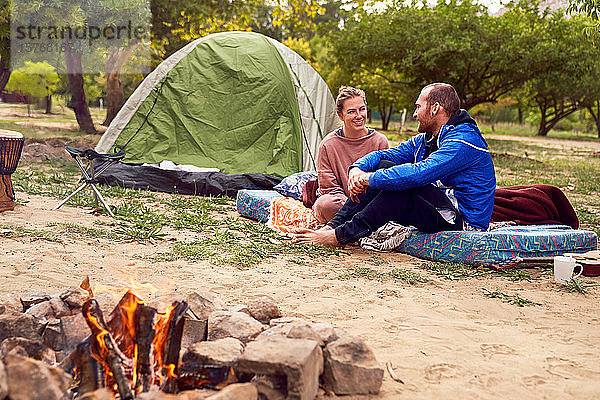 Junges Paar beim Zelten  das sich auf dem Campingplatz unterhält