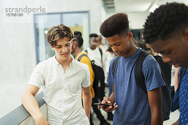 Schüler der Junior High School benutzen ihr Smartphone im Korridor