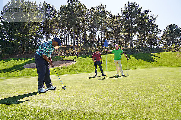 Golfer beim Putten auf einem sonnigen Golfplatz