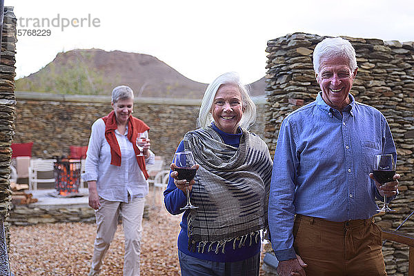Porträt eines glücklichen älteren Paares beim Weintrinken auf der Hotelterrasse