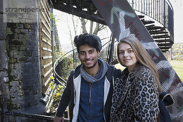 Portrait glückliches junges Paar an städtischer Treppe