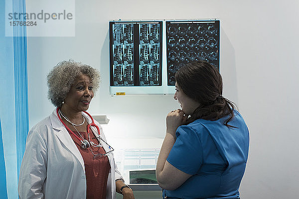 Ärztin und Krankenschwester besprechen Röntgenbilder in einem Krankenhaus
