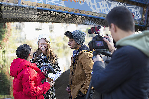 Junge Filmstudenten filmen unter einer Stadtbrücke