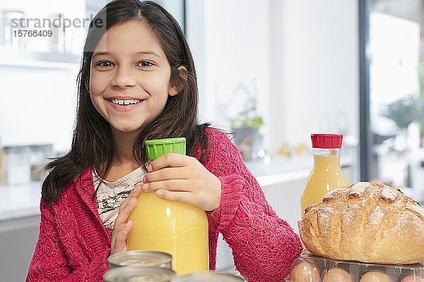 Portrait lächelndes Mädchen mit Orangensaft in der Küche