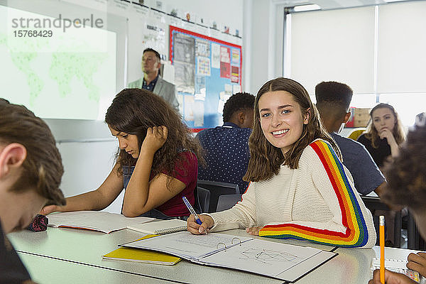 Porträt zuversichtlich High-School-Mädchen Studentin Notizen während Geographie Lektion im Klassenzimmer