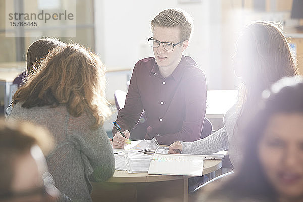 Junge Studenten studieren gemeinsam in einem sonnigen Klassenzimmer