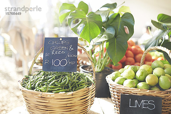 Körbe mit frischem Grünzeug und Limetten auf dem Bauernmarkt