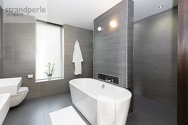 Modernes graues und weißes Badezimmer mit Badewanne