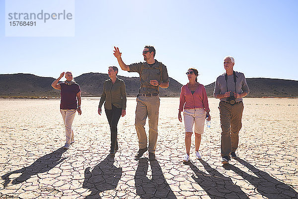 Safari-Reiseleiter führt Gruppe in der sonnigen Trockenwüste Südafrikas