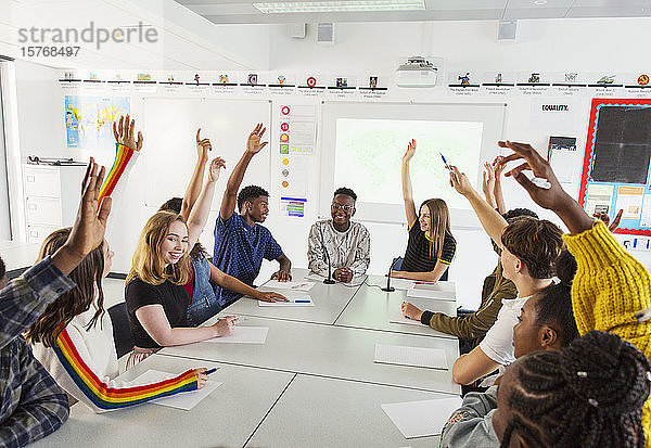 Gymnasiasten mit erhobenen Händen im Debattierkurs