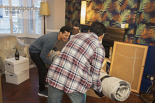 Männer bringen einen Teppich ins Wohnzimmer eines neuen Hauses