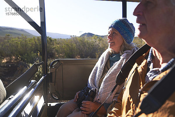 Glückliches älteres Paar fährt in einem Safari-Geländewagen