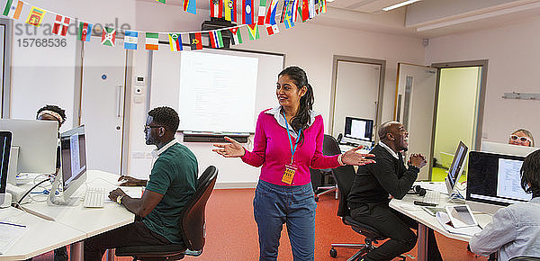 Community College-Lehrer  der erwachsene Studenten bei der Nutzung von Computern im Klassenzimmer anleitet