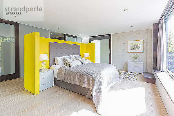 Modernes Schlafzimmer mit gelbem und grauem Kopfteil