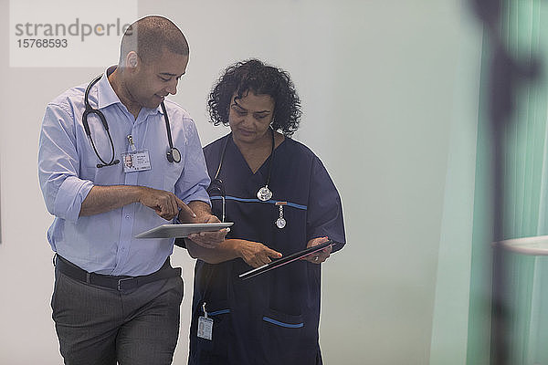 Ärzte mit digitalen Tablets im Gespräch im Krankenhaus
