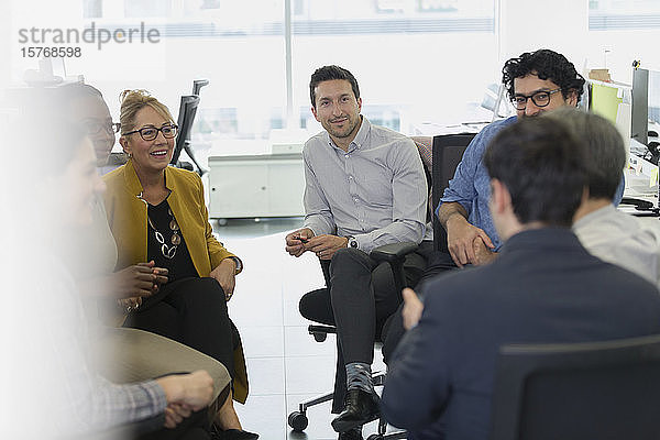 Geschäftsleute treffen sich in einem Kreis im Büro