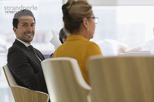Porträt eines lächelnden  zuversichtlichen Geschäftsmannes in einer Besprechung im Konferenzraum