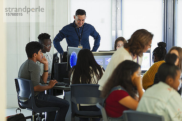 Schüler der Mittelstufe und Lehrer verwenden Computer im Computerraum