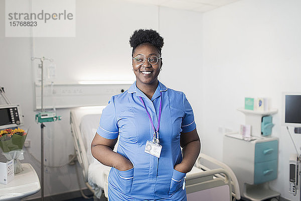 Porträt einer selbstbewussten  lächelnden Krankenschwester in einem Krankenhauszimmer