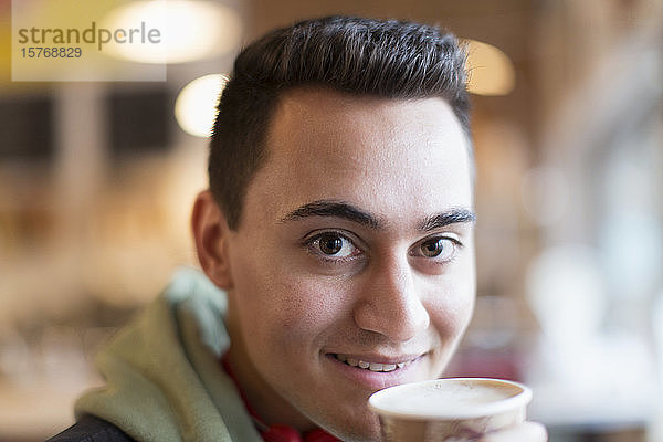 Nahaufnahme Porträt selbstbewusster junger Mann beim Kaffeetrinken