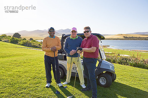 Porträt zuversichtlich  reife männliche Freunde Golf spielen auf sonnigen Golfplatz