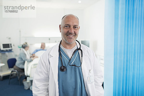 Porträt eines selbstbewussten  lächelnden männlichen Arztes in einem Krankenhauszimmer
