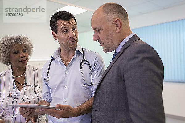 Ärzte mit digitalem Tablet bei der Visite  Beratung im Krankenhaus